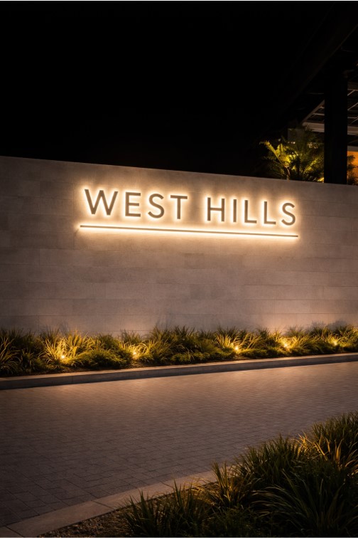 Illuminated wall signage at night, West Hills development